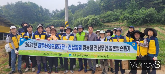 김귀남 광주신용보증재단 이사장과 김해종 농협무안군지부장 등이 10일 무안군 몽탄면 양파 재배농가에서 일손돕기를 마친 후 기념촬영을 하고 있다/사진=농협전남본부 제공.