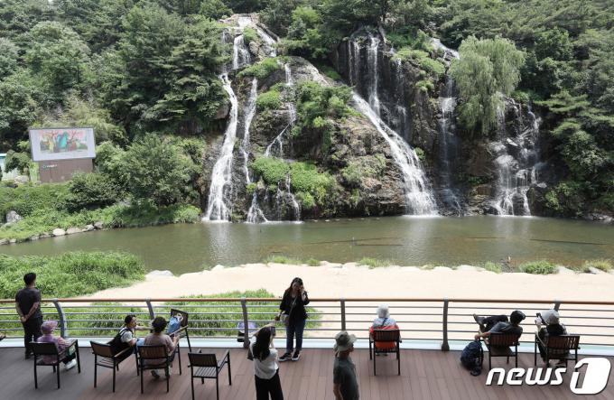 지난해 서울 서대문구 홍제천에서 시민들이 인공폭포를 보며 더위를 식히고 있다. ⓒ News1 김민지 기자