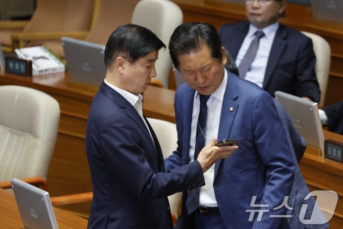 [사진] 휴대전화 보며 대화 나누는 정청래·이해식