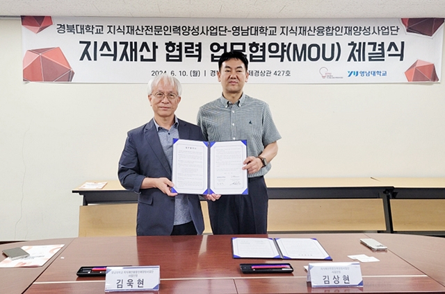 김상현 경북대 지식재산전문인력양성사업단장(오른쪽)과 김욱현 영남대 지식재산융합인재양성사업단장(왼쪽)이 업무협약서를 들어보이고 있다./사진제공=경북대학교