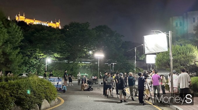 지난해 7월 스튜디오 오키브스와 스튜디오투유가 공동 제작한 OTT드라마 '내 친구의 졸업식'의 출연 배우와 제작진이 광주대학교 캠퍼스를 배경으로 촬영을 하고 있다. 뒷 상단 건물은 광주대학교 본관/사진=광주대학교 제공.
