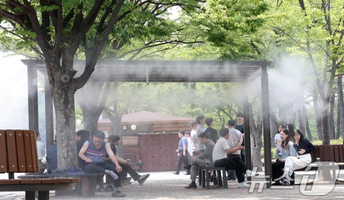 전국 대부분 지역에서 체감온도가 최고 31도 이상 오르며 무더운 날씨를 보인 11일 서울 영등포구 여의도공원에서 시민들이 쿨링포그 아래 휴식을 취하고 있다. 2024.6.11/뉴스1 ⓒ News1 김성진 기자