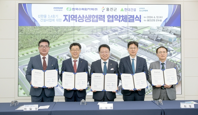 한수원을 비롯한 울진군, 현대건설 등 신한울3·4호기 시공사 관계자들이 업무협약서를 들어보이고 있다./사진제공=한국수력원자력