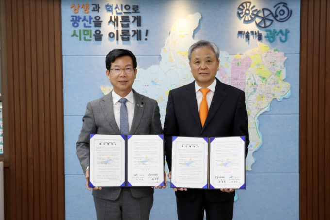 박병규 광주시 광산구청장(왼쪽)이 13일 구청에서 호용한 (사)어르신의 안부를 묻는 우유배달 이사장과 업무협약을 체결하고 있다./사진=광주 광산구청