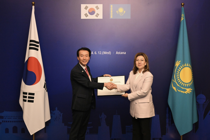 김성주 BNK캐피탈 대표(왼쪽)가 마지나 아빌카시모바 카자흐스탄 금융감독원장으로부터 은행업 예비인가증을 받고 있다./사진=부산은행