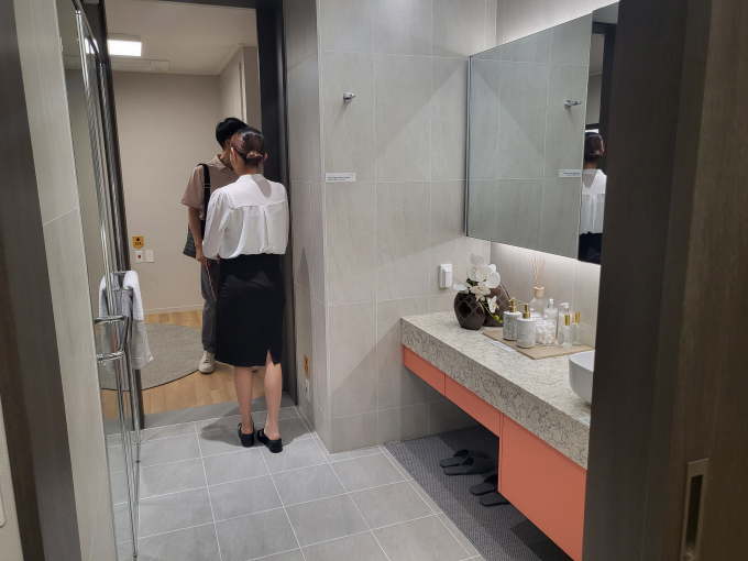 침실-화장실-서재로 이어지는 공간을 방문객이 홍보관 관계자와 함께 둘러보고 있다. 