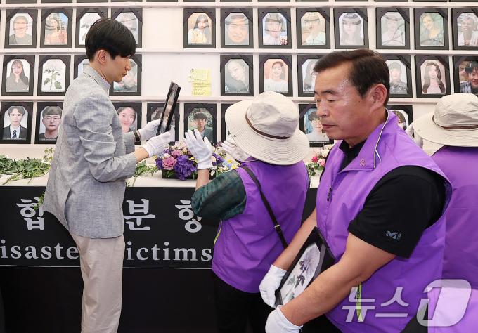 [사진] 영정사진 전달받는 유가족들