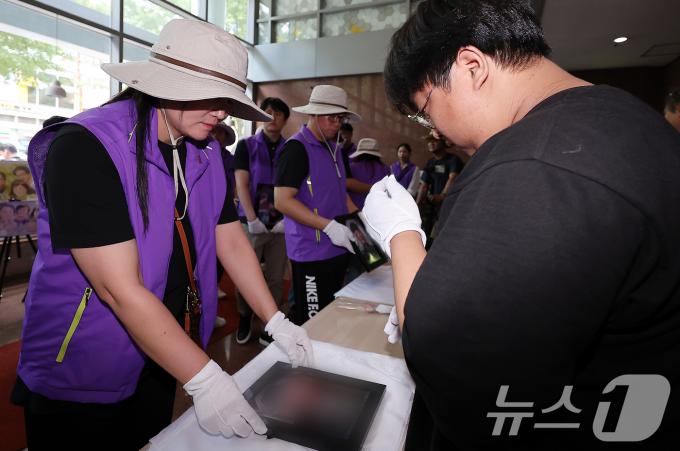 [사진] 서울광장 분향소 영정 전달하는 유가족들