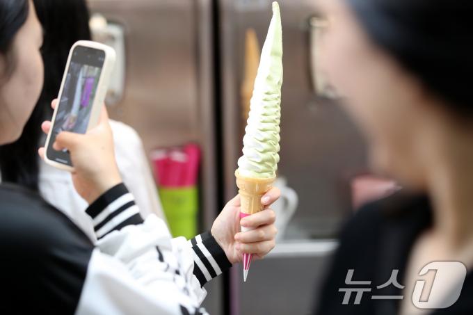 서울의 낮 최고기온이 30도를 기록하는 등 불볕더위가 계속된 17일 오후 서울 중구 명동거리에서 외국인 관광객이 아이스크림을 먹으며 더위를 식히고 있다. 2024.6.17/뉴스1 ⓒ News1 임세영 기자