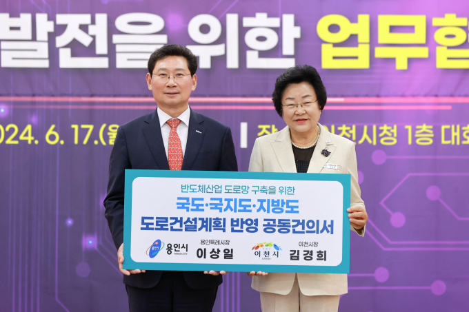 이상일 용인특례시장(왼쪽)과 김경희 이천시장(오른쪽)이 17일 이천시청에서 열린 '반도체산업 기반 공동발전을 위한 업무협약식'에서 '도로건설계획 반영 공동건의서'를 들고 사진촬영을 하고 있다. / 사진제공=용인특례시