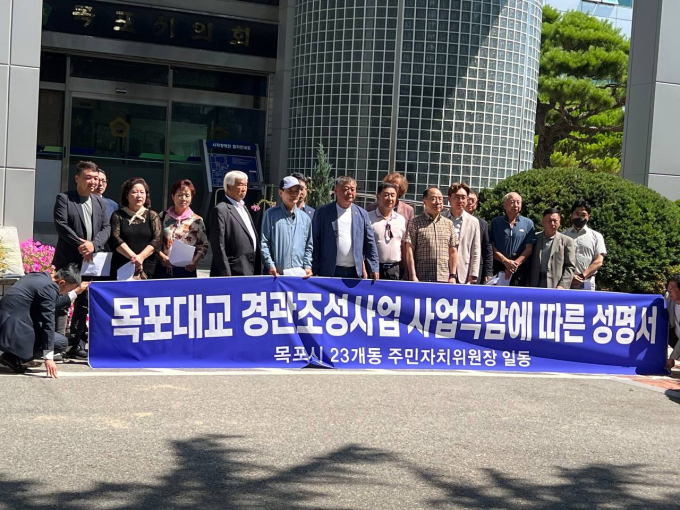 목포시 23개동 주민자치위원장 대책위가 18일 오전 목포시의회 앞에서 기자회견을 갖고 '목포대교 경관조명 특화사업'의 추진을 촉구하고 있다.