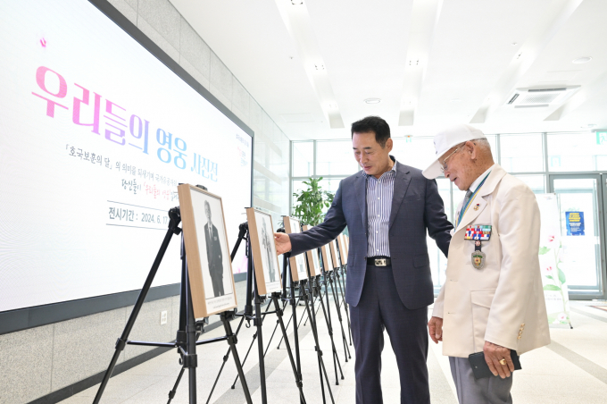 포천시청 신청사 1층 로비에서 열리고 있는 '우리들의 영웅 사진전'에서 백경현 시장이 보훈 유공자 어르신을 안내하고 있다. /사진제공=포천시