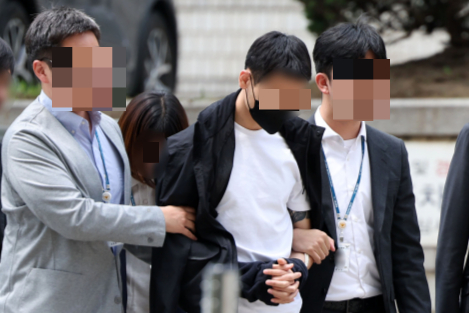 경복궁 담벼락에 낙서를 사주한 혐의로 검거된 30대 남성 강모씨가 구속 기소됐다. 사진은 지난달 25일 서울 서초구 서울중앙지법에서 열린 영장실질심에 출석하고 있는 강씨(가운데). /사진=뉴시스