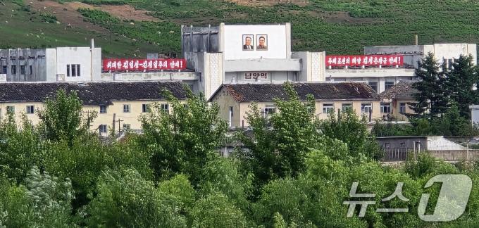 지난 12일 중국과 북한의 국경지역인 중국 지린성 옌볜 조선족자치주 도문시 두만강 강변공원에서 두만강 너머로 김일성·김정일의 대형 초상화가 그려진 북한 함경북도 온성군(남양노동자구) 남양역이 보이고 있다. (공동취재) 2024.6.17/뉴스1 ⓒ News1 이재명 기자