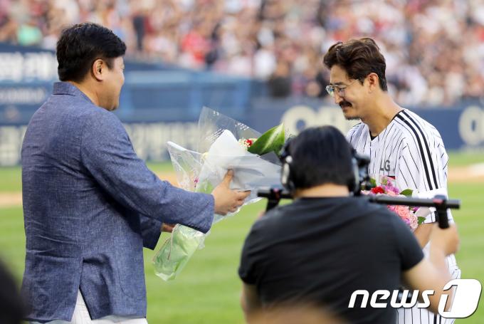 LG 박용택이 23일 오후 서울 송파구 잠실야구장에서 열린 '프로야구 2018 KBO 리그' LG 트윈스와 롯데 자이언츠의 경기에서 통산 최다안타 기록을 쓰고 이전 기록자인 양준혁에게 축하의 꽃다발을 선물받고 있다. 2018.6.23/뉴스1 ⓒ News1 이재명 기자