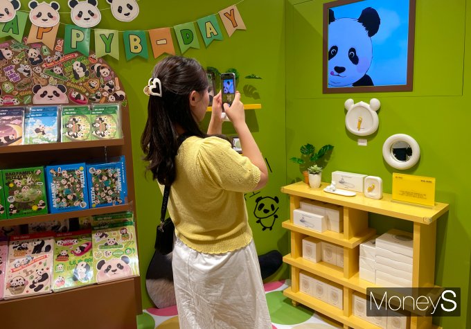 지난 21일 서울 여의도 더현대서울 5층 바오패밀리 팝업스토어에서 한 방문객이 푸바오 그림을 촬영하고 있다. /사진=서지영 기자