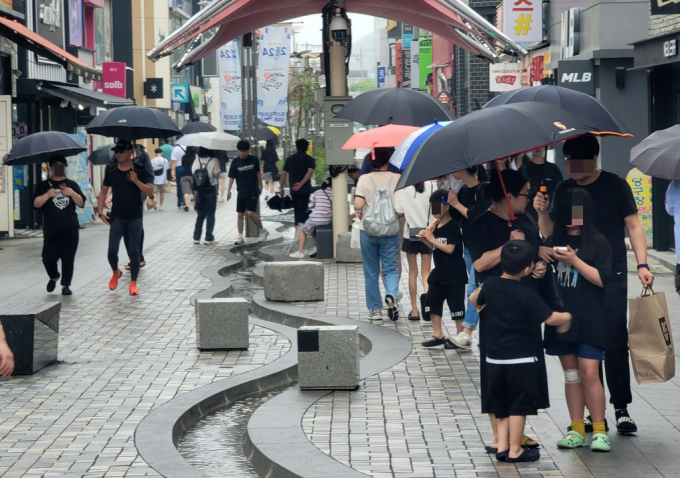23일 경북 포항시 북구 중앙상가 실개천에서 우산을 든 시민들이 휴일을 보내고 있다./사진=뉴스1 /사진=(포항=뉴스1) 최창호 기자