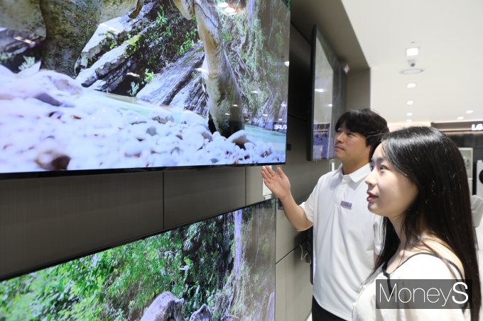 롯데백화점 광주점 9층 가전매장 관계자가 여성고객에게 진열 TV 제품에 대해 설명하고 있다/사진=롯데백화점 홍보 3팀 제공. 