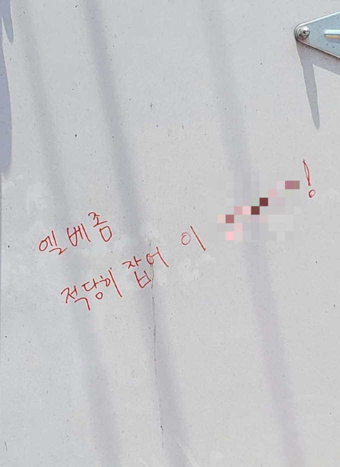택배 기사인 글쓴이가 공개한 사진 속에는 누군가가 택배 차량의 뒤편에 빨간 유성 매직으로 욕설을 적었다. /사진=보배드림 캡처