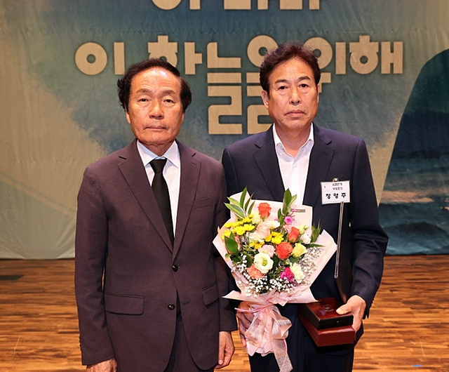 6·25전쟁에 참전해 전사한 고 정휘봉 일병의 조카인 정영주(오른쪽)씨가 김주수 의성군수로부터 화랑무공훈장을 전수받은 뒤 기념사진을 촬영하고 있다./사진제공=경북 의성군