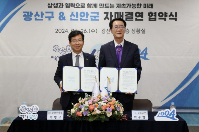 박병규 광주시 광산구청장(왼쪽)과 박우량 전남 신안군수가 양 도시의 지속 가능한 미래를 함께 만들기 위해 26일 광산구청에서 자매결연을 체결하고 있다./사진=광주 광산구청