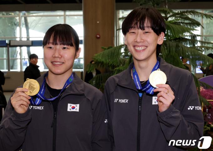 여자 배드민턴 대표팀 백하나(왼쪽)와 이소희가 19일 오후 인천국제공항 제1터미널을 통해 귀국한 뒤 전영오픈 여자 복식 금메달을 들어보이고 있다. 2024.3.19/뉴스1 ⓒ News1 장수영 기자