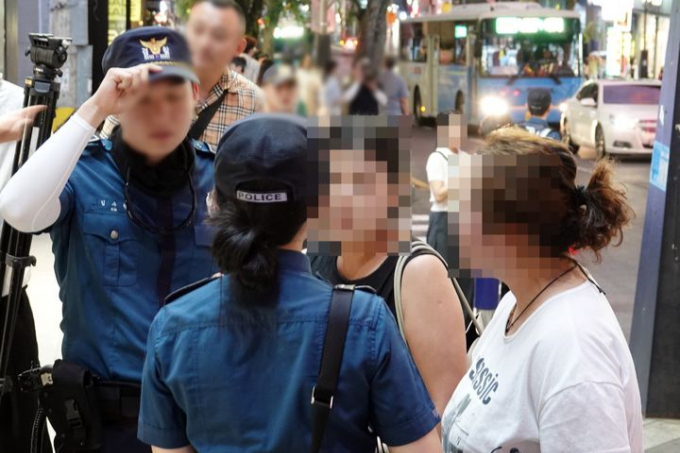제주경찰청이 지난 25일 오후 제주시 연동에서 무단횡단을 한 중국인 관광객을 적발해 조사하고 있다. /사진=뉴시스