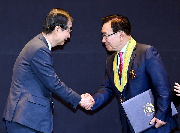 김기병 롯데관광개발 대표이사 회장이 국민훈장 모란장을 받았다. 한덕수 국무총리(왼쪽)와 김 회장이 국가보훈부에서 주관한 정부포상식에서 악수하고 있다. /사진=롯데관광개발