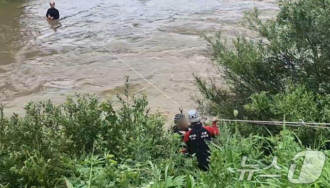 30일 오전 가평군 청평면 조종천 철교하천 중간에 호우로 불어난 물에 고립된 외국인 남성이 소방대원에 의해 구조되고 있다. (경기북부소방재난본부 제공)2024.6.30/뉴스1 ⓒ News1 박대준 기자