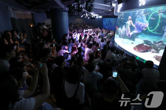 30일 오후 서울 영등포구 여의도 아쿠아플라넷63을 찾은 가족 단위 관람객들이 인어공주의 로맨틱 공연을 감상하고 있다. 2024.6.30/뉴스1 ⓒ News1 박정호 기자