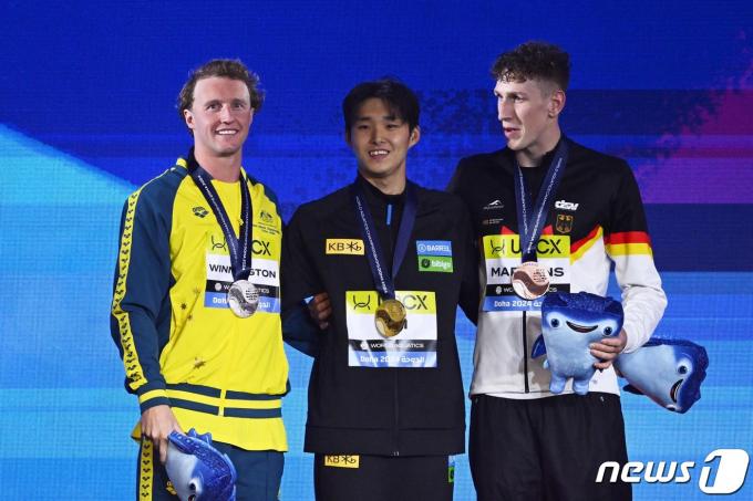 12일(한국시간) 열린 2024 세계수영선수권대회 경영 남자 자유형 400m 결승에서 우승한 김우민(강원도청)이 시상식에서 은메달을 획득한 호주의 일라이자 위닝턴, 동메달을 획득한 루카스 마르텐스와 기념 촬영을 하고 있다.  ⓒ AFP=뉴스1 ⓒ News1 김진환 기자