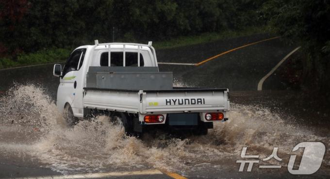 제주에 올해 첫 장맛비가 내린 20일 오후 물에 잠긴 서귀포시 한 도로 를 차량이 물보라를 일으키며 지나가고 있다.  ⓒ News1 고동명 기자