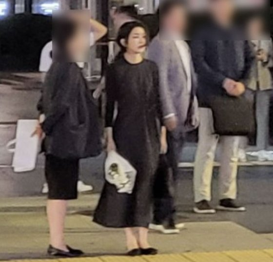 김건희 여사가 지난 3일 밤 10시50분쯤 하얀 국화꽃을 든 채 서울시청역 역주행 사고 현장을 찾았다. 사진은 현장 신호등을 건너는 김건희 여사의 모습. /사진=온라인 커뮤니티(디시인사이드 갈무리)