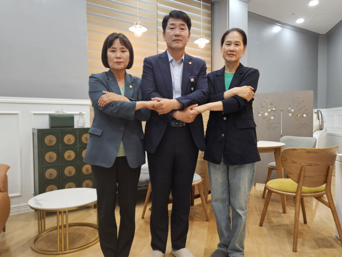 배정수 화성시의회 의장(가운데)과 위영란 의원(왼쪽), 김미영 의원(오른쪽)이 후반기 원구성에 합의한 후 손을 맞잡고 있다. / 사진제공=화성시의회