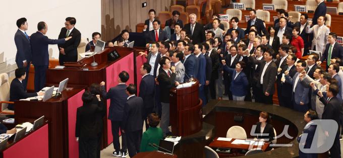 우원식 국회의장과 추경호 국민의힘 원내대표, 박찬대 원내대표가 4일 오후 서울 여의도 국회 본회의장에서 해병대원 특검법 무제한 토론(필리버스터) 중지를 선언되고 종결동의의 건이 상정되자 논의하고 있다. 오른편에서는 국민의힘 의원들이 의장석에 몰려가 항의하고 있다. 2024.7.4/뉴스1 ⓒ News1 김민지 기자