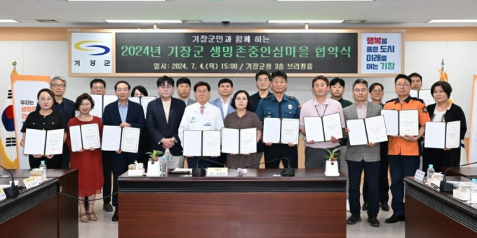 정종복 기장군수(앞줄 왼쪽 다섯번째)가 '생명존중 안심마을’에 참여하는 경찰, 119안전센터 등과 업무협약을 체결하고 관계자들과 기념촬영을 하고 있다./사진=기장군