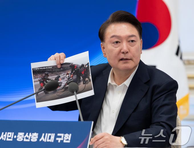 윤석열 대통령이 3일 서울 청와대 영빈관에서 열린 '역동경제로 서민·중산층 시대 구현' 하반기 경제정책방향 및 역동경제 로드맵 행사에서 F1 경기 도중 피트스탑 장면을 찍은 사진을 들고 발언을 하고 있다. (대통령실 제공) 2024.7.3/뉴스1 ⓒ News1 송원영 기자