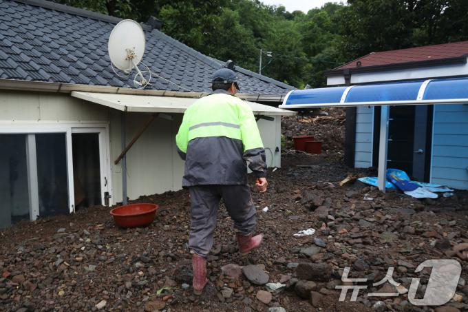 8일 오후 경북 영양군 입암면 금학리 한 주택에서 주민 이명섭(73) 씨가 집중호우로 뒷산에서 쏟아진 토사에 갇힌 이웃집을 살펴보고 있다. 이 씨는 