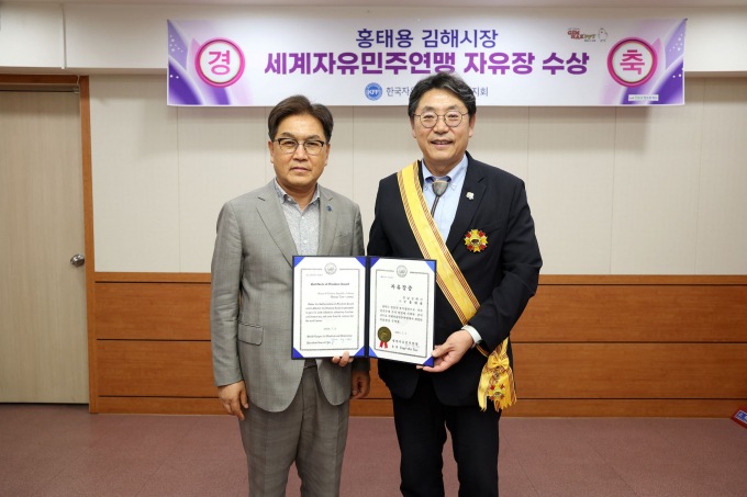 홍태용 김해시장(오른쪽)이 세계자유민주연맹 자유장을 수상한 뒤 김용수 자총 경남지부 회장과 기념촬영을 하고 있다./사진=김해시