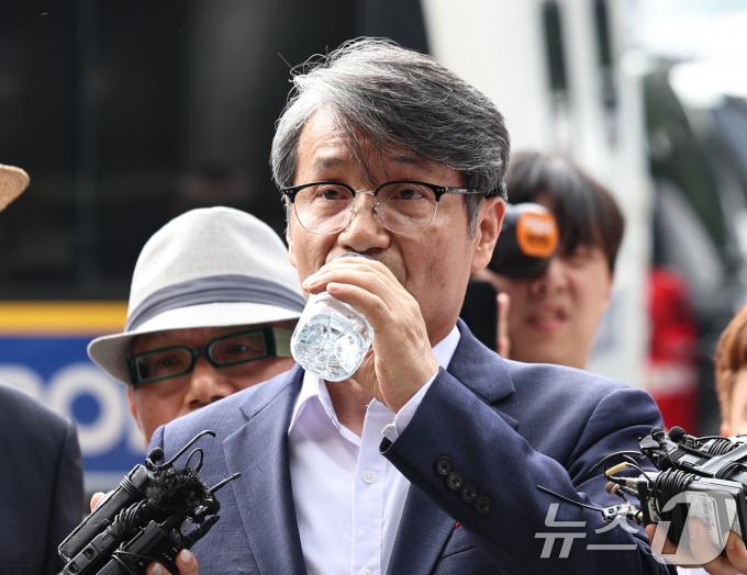 최재영 목사가 4일 오전 서울 서초경찰서에서 스토킹 혐의로 피고발인 조사를 앞두고 입장을 밝히며 목을 축이고 있다. 최 목사는 2022년 6월 부터 김건희 여사에게 10여 차례 만남을 요청하고 명품가방 등을 전달하는 장면을 몰래 촬영한 혐의를 받고 있다. 2024.7.4/뉴스1 ⓒ News1 구윤성 기자