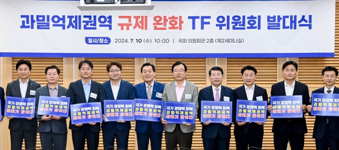 과밀억제권역 규제 완화 TF위원회 대표위원장으로 선출된 이재준 수원시장(오른쪽에서 여섯 번째부터), 염태영 의원, 이동환 고양시장 등이 발대식 후 '국가경쟁력 회복 과밀억제권역 완화가 답이다'라는 문구가 적힌 손팻말을 들고 기념촬영을 하고 있다. 사진제공=수원시  