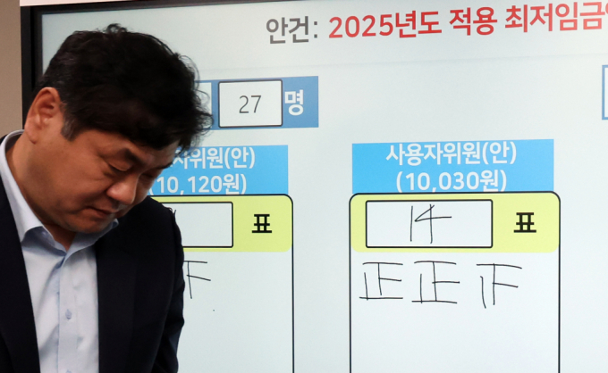 이인재 최저임금위원장이 12일 새벽 세종시 정부세종청사에서 2025년도 적용 최저임금에 대한 표결 결과 앞을 지나고 있다. / 사진=뉴시스 강종민 기자 /사진=강종민