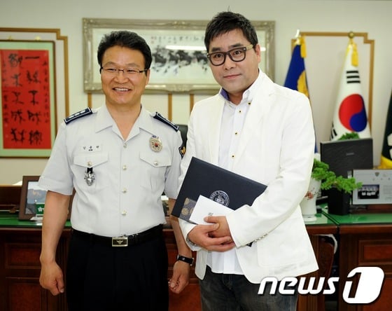 서울지방경찰청은 25일 오전 서울경찰청장실에서 성추행범을 맨 손으로 때려잡은 이병훈 야구해설위원에게 감사장과 포상금을 수여했다. 김용판 서울경찰청장과 이 해설위원이 취재진을 향해 포즈를 취하고 있다. 이병훈 위원은 지난 21일 새벽 둘째 아들 용하(17)와 함께 서울 낙성대동에 있는 놀이터에 아들의 훈련을 돕던 중 여자 비명소리를 듣고 달려간 어두운 골목속에서 수상한 20대 초반 남성을 발견했다. 이병훈 해설위원은 도망치는 남성을 쫓아가 격투 끝에 붙잡았고 지구대 경찰에 인계했다.2012.5.25/뉴스1