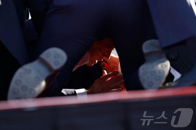 [사진] 총격 사건에 경호원 보호 받으며 바닥 엎드린 트럼프