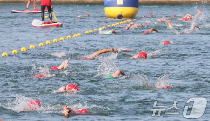 14일 오전 서울 송파구 롯데월드타워 일대에서 열린 '2024 롯데 아쿠아슬론'에 출전한 참가자들이 석촌호수에서 수영을 하고 있다.  (공동취재) 2024.7.14/뉴스1 ⓒ News1 임세영 기자