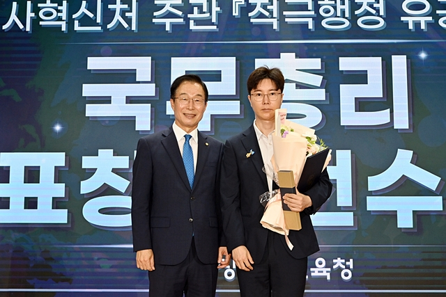  임종식 경북도교육감(왼쪽)이 국무총리 표창을 받은 뒤 안승완 주무관과 기념촬영을 하고 있다./사진제공=경상북도교육청