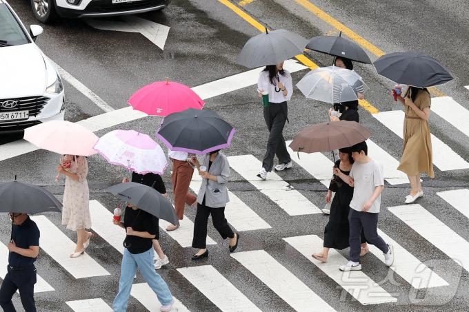 남부지방에 장맛비가 내린 19일 광주 북구청 사거리 교차로에서 우산을 쓴 구청 공직자들이 점심시간 청으로 복귀하고 있다.(광주 북구 제공)2024.7.19/뉴스1