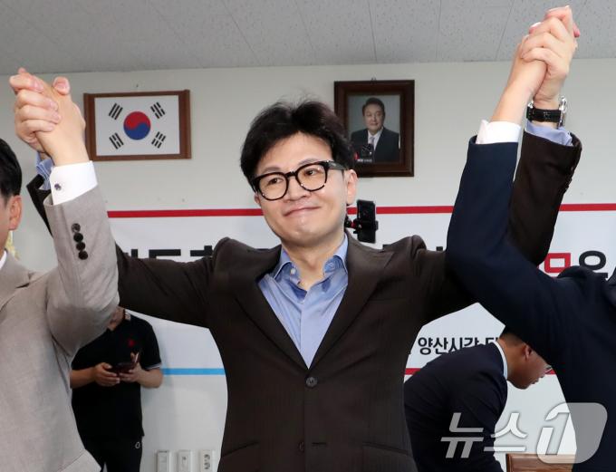 한동훈 국민의힘 당대표 후보가 21일 오전 경남 양산시 물금읍 윤영석 의원 사무실에 마련된 양산시갑 당원협의회를 찾아 참석자들과 손을 들어올리고 있다. 2024.7.21/뉴스1 ⓒ News1 윤일지 기자