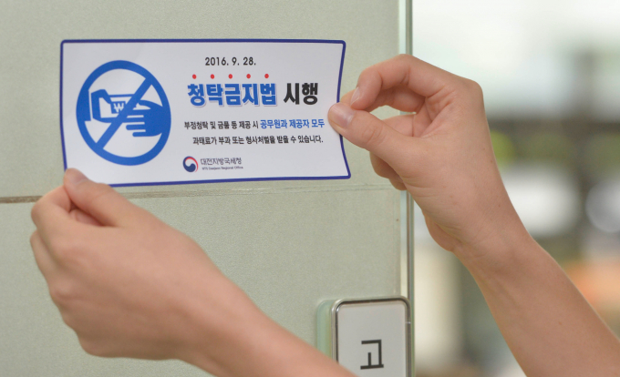 정부가 '김영란법'이라고 불리는 청탁금지법(부정청탁 및 금품등 수수의 금지에 관한 법률) 손질에 나선다. 사진은 지난 2016년 8월 대전지방국세청이 ‘청탁금지법 알림 스티커’를 전국 최초로 제작해 지방청의 사무실 출입문에 부착된 모습. /사진=뉴스1