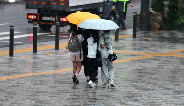 오는 23일 전국이 흐린 가운데 더운 날씨가 예상되며 일부 지역에서 비 소식이 있을 전망이다. 사진은 지난 22일 서울 중구 서울시의회 앞에서 우산을 쓴 학생들. /사진=뉴시스